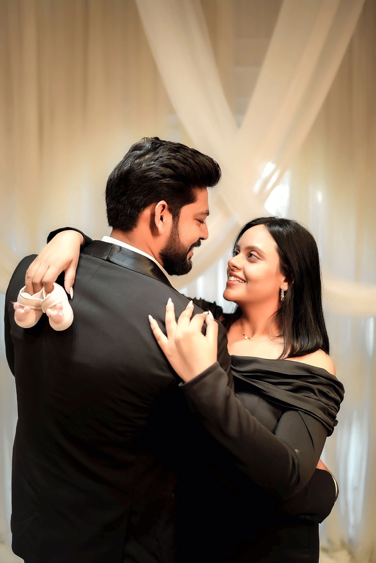 Black outfit maternity couple portrait with baby shoes