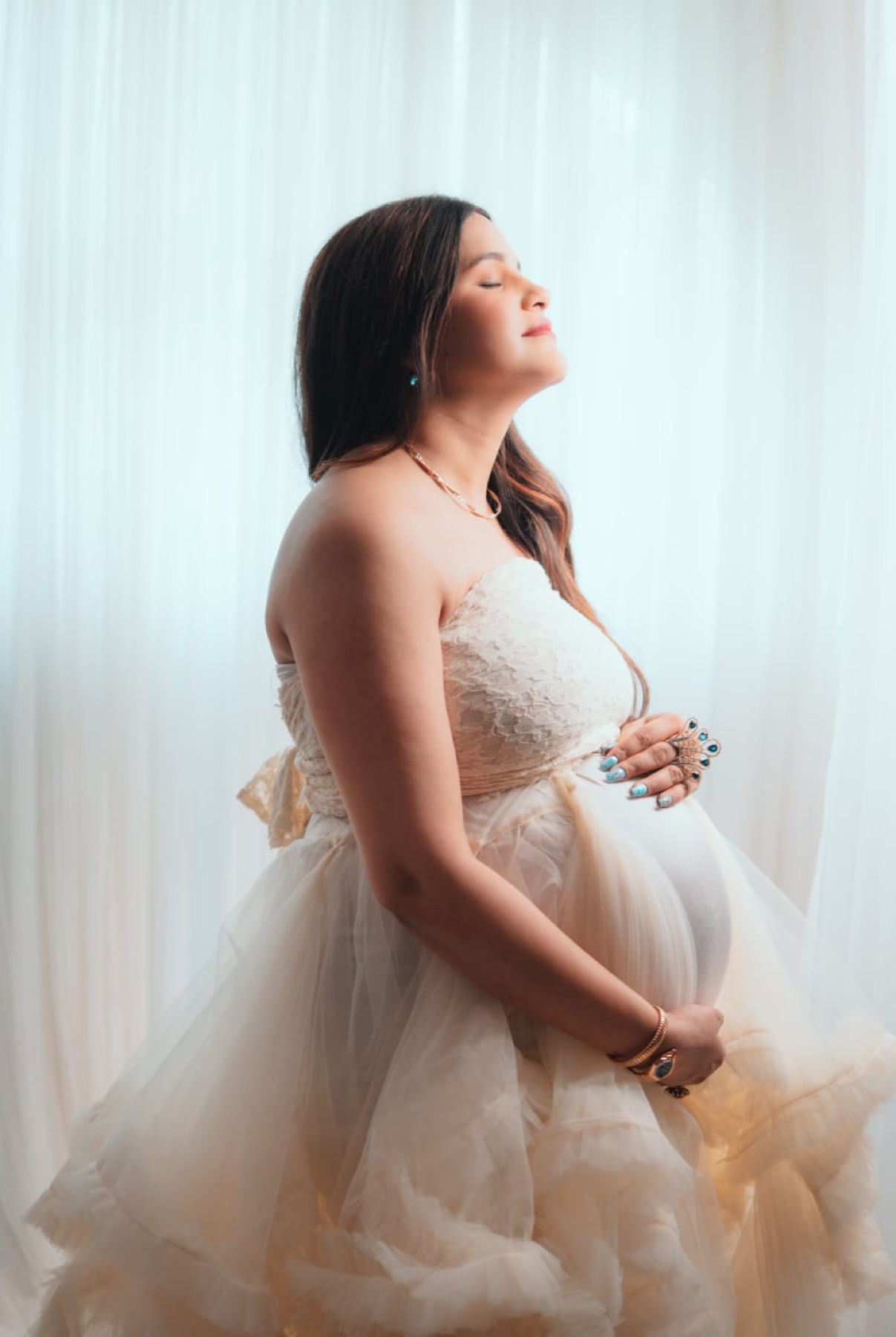 White maternity side profile portrait in premium gown